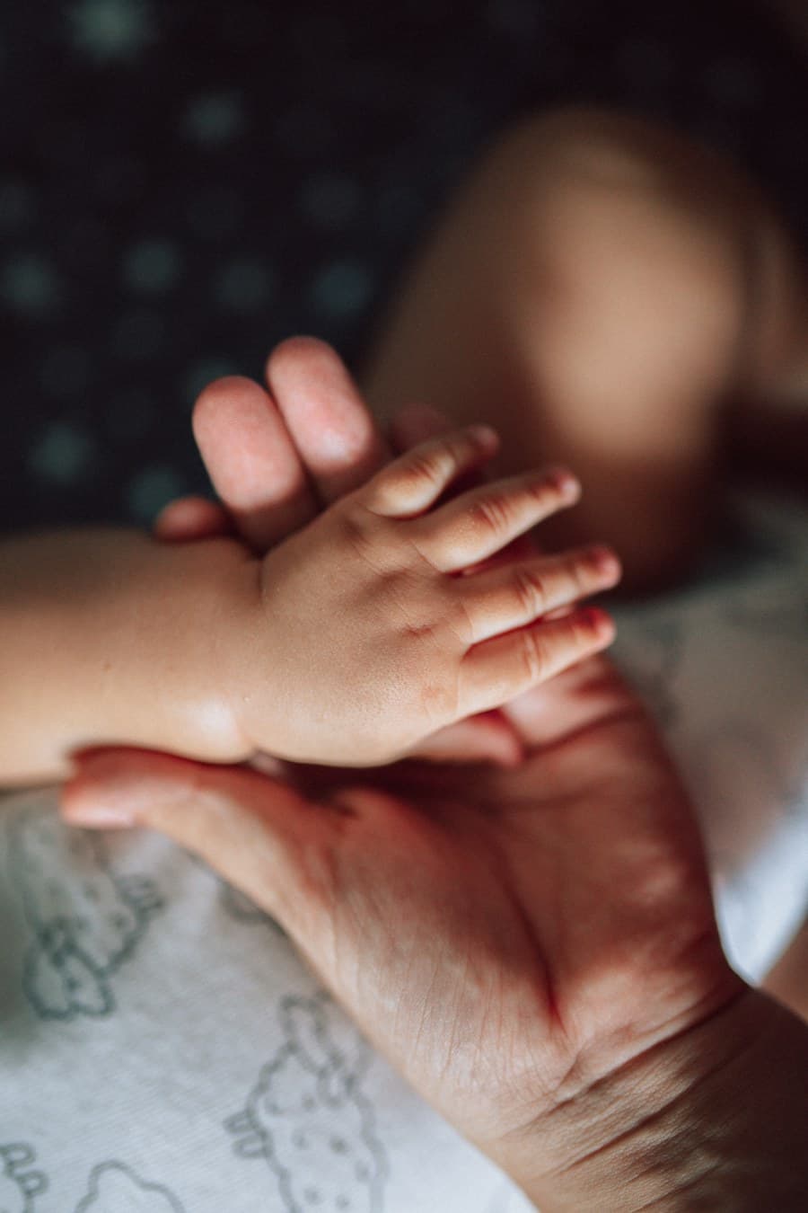 Tangan mungil bayi dalam genggaman orang tuanya